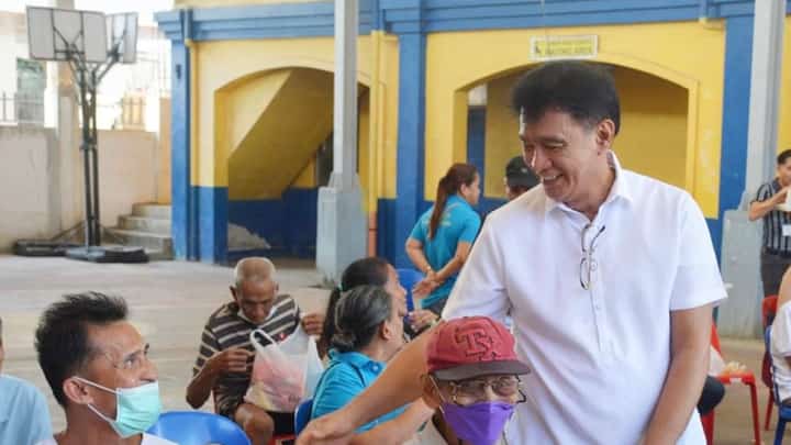 Dr. Arturo Cunanan Jr., Culion Sanitarium and General Hospital chief, greets senior citizens who are waiting at the hospital vicinity.