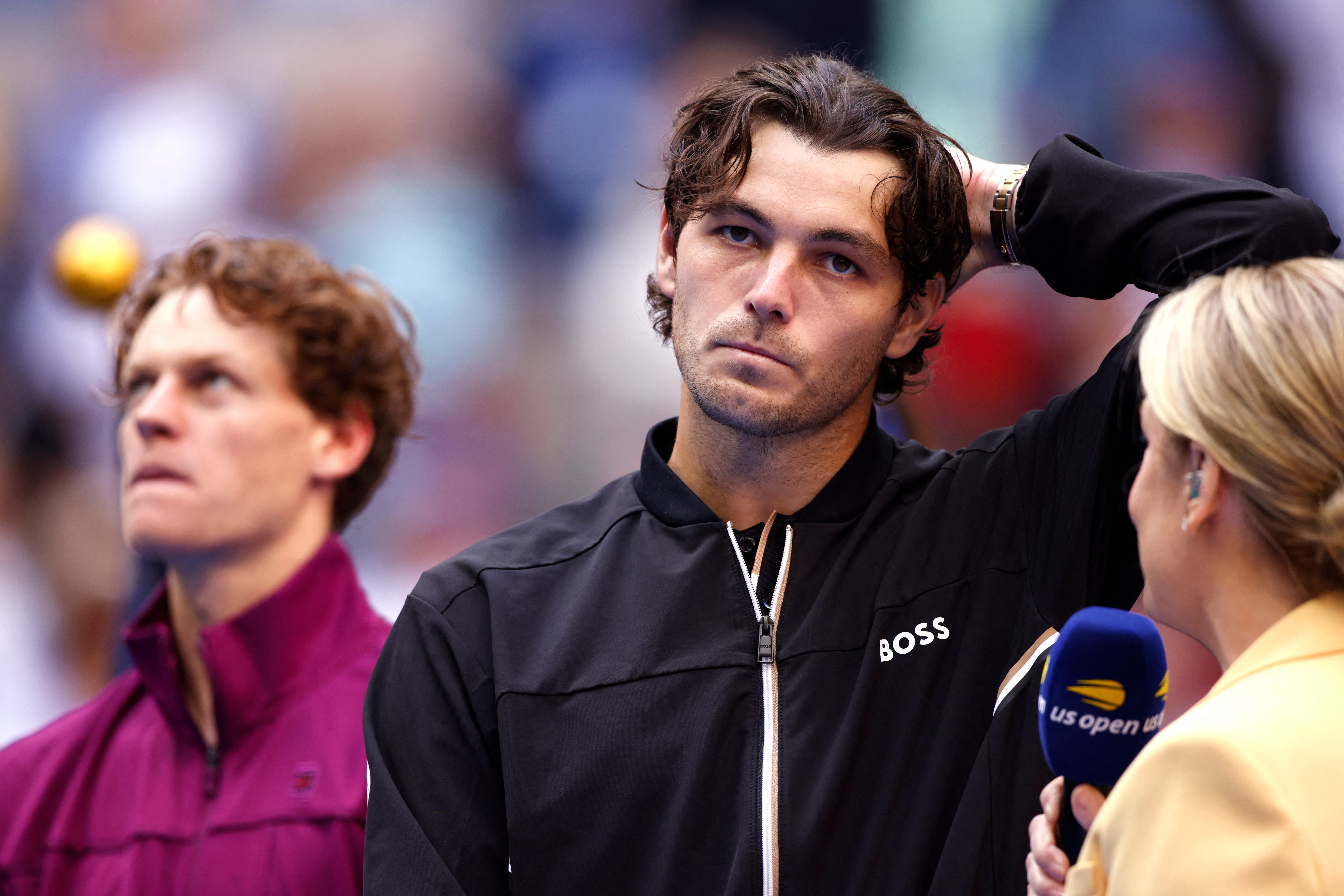 USA's Taylor Fritz (C) is interviewed after Italy's Jannik Sinner (L) won their men's final match on day fourteen of the US Open tennis tournament at the USTA Billie Jean King National Tennis Center in New York City, on 8 September 2024.