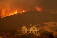 Los Angeles wildfire explodes, engulfing homes