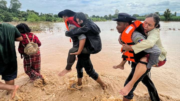Police carry residents affected by flooding through floodwaters in Pyinmana town, located in Myanmar's Naypyidaw region on September 13, 2024, following heavy rains in the aftermath of Typhoon Yagi. Typhoon Yagi brought a colossal deluge of rain that has inundated a swathe of northern Vietnam, Laos, Thailand and Myanmar, triggering deadly landslides and widespread river flooding.