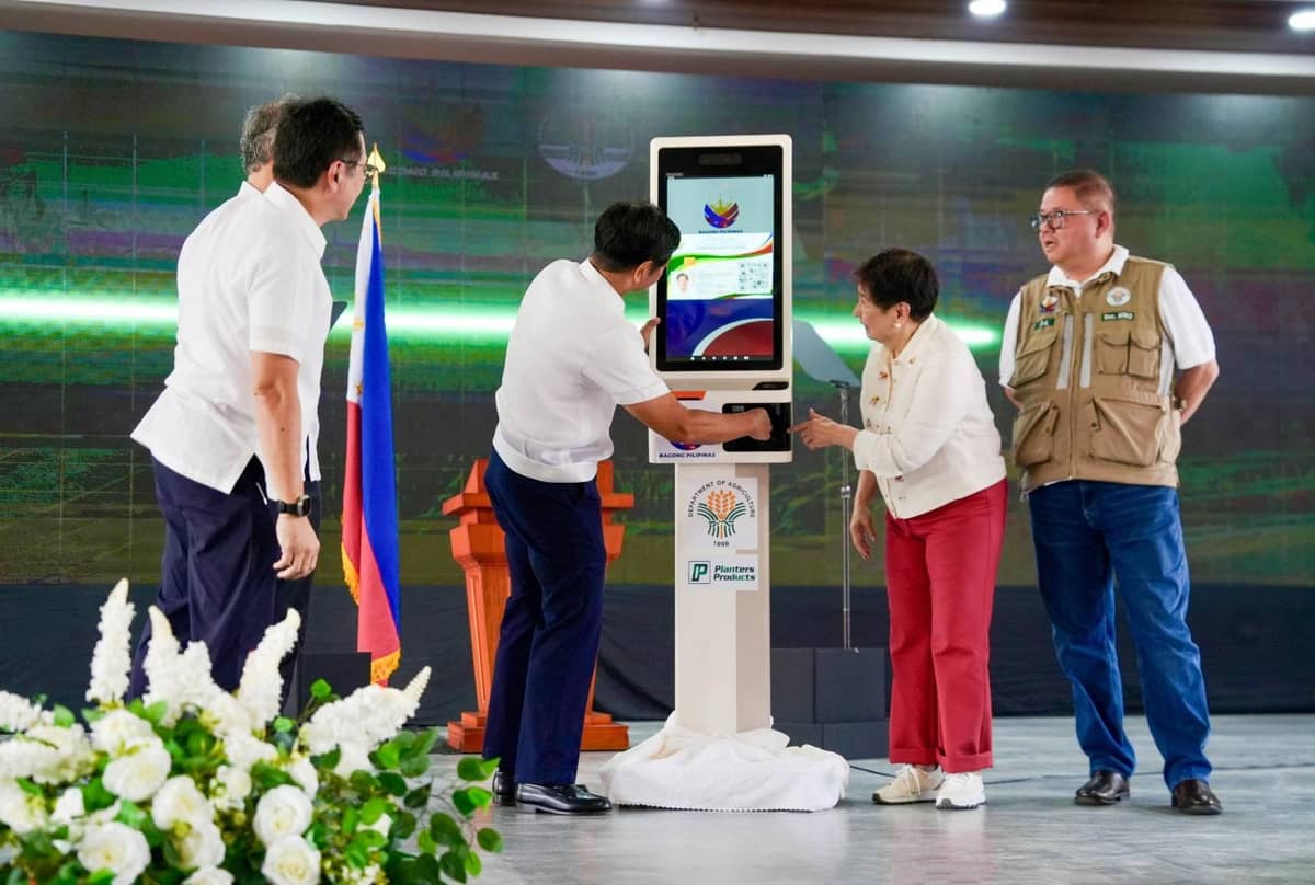 PRESIDENT Ferdinand Marcos Jr. inserts a sample Interventions Monitoring Card on an ATM as Planters Product Inc. president and CEO Maria Zenaida Angping (2nd from right), Agriculture Secretary Francisco Tiu Laurel Jr. (right) and DBP president and CEO Michael de Jesus (hidden) look on.