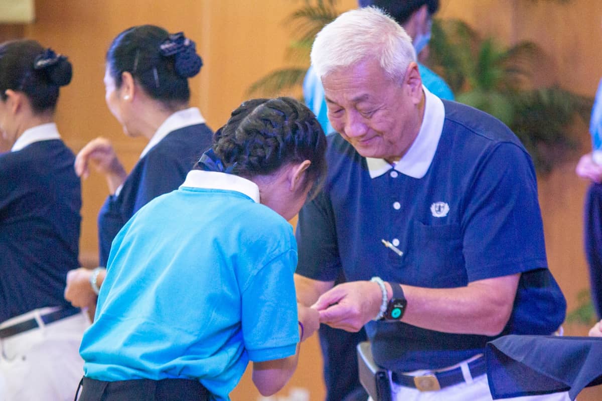 TZU Chi Philippines Foundation CEO Henry Yuñez presents a Tzu Chi ID to one of the new scholars.