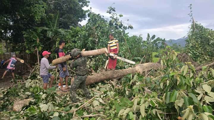 Troops from the Philippine Marines assist in clearing operations of fallen trees and debris swept away by the flood in a Palawan town.