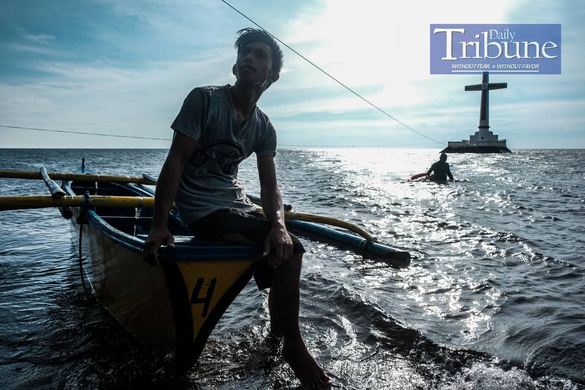 Raymart Dahang, a native of Camiguin, has made being a bangkero a living, transporting tourists to the large cross of the Sunken Cemetery.