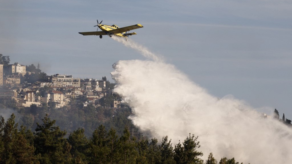 A firefighting aircraft releases flame retardant to extinguish fires caused by rockets launched from southern Lebanon which landed on the outskirts of Safed, in the upper Galilee on 21 September 2024.
