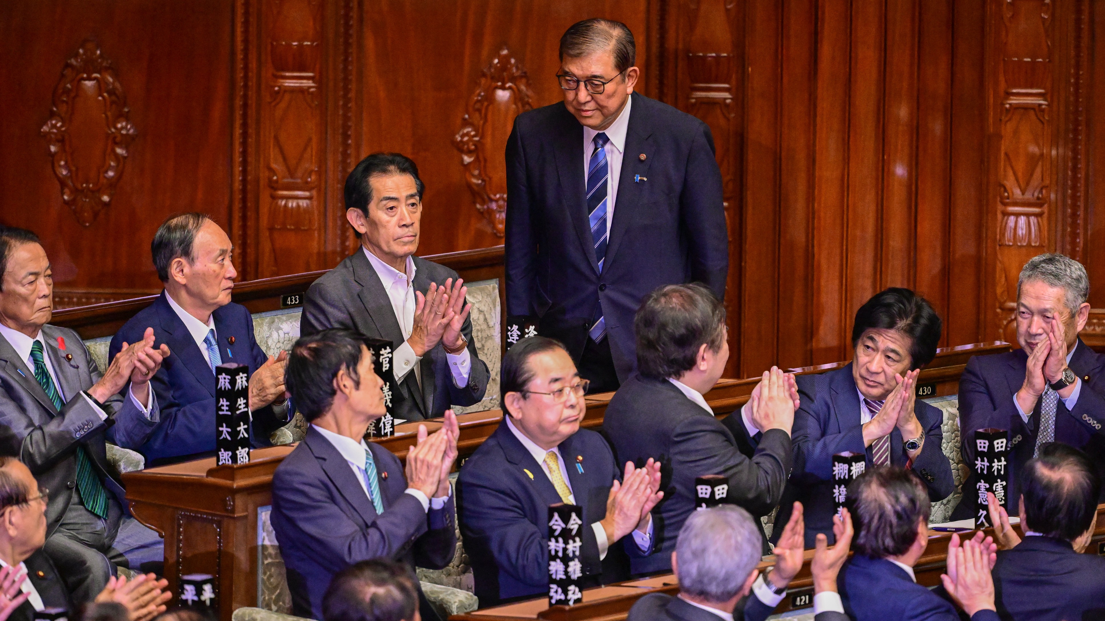 Leader of Japan's ruling Liberal Democratic Party (LDP) Shigeru Ishiba (C top) stands up to acknowledge the applause after he was selected as the new prime minister during an extraordinary session of the lower house of parliament in Tokyo on 1 October 2024.
