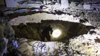 Members of Israel's Home Front Command and police forces inspect a crater left by an exploded projectile at a heavily damaged school building in Israel's southern city of Gedera on 1 October 2024, after Iran launched a barrage of missiles at Israel in response to the killings of Lebanese Hezbollah leader Nasrallah and other Iran-backed militants.