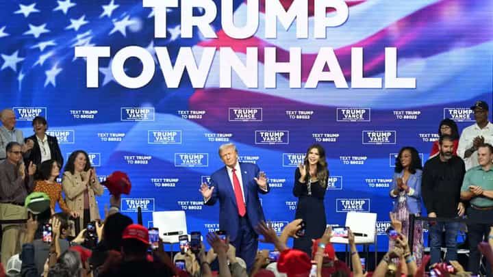 Former US President and Republican presidential candidate Donald Trump, with moderator and South Dakota Governor Kristi Noem (right), arrives for a town hall at the Greater Philadelphia Expo Center and Fairgrounds in Oaks, Pennsylvania, on October 14, 2024.
