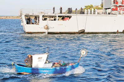 Italian navy brings first migrants to Albania center