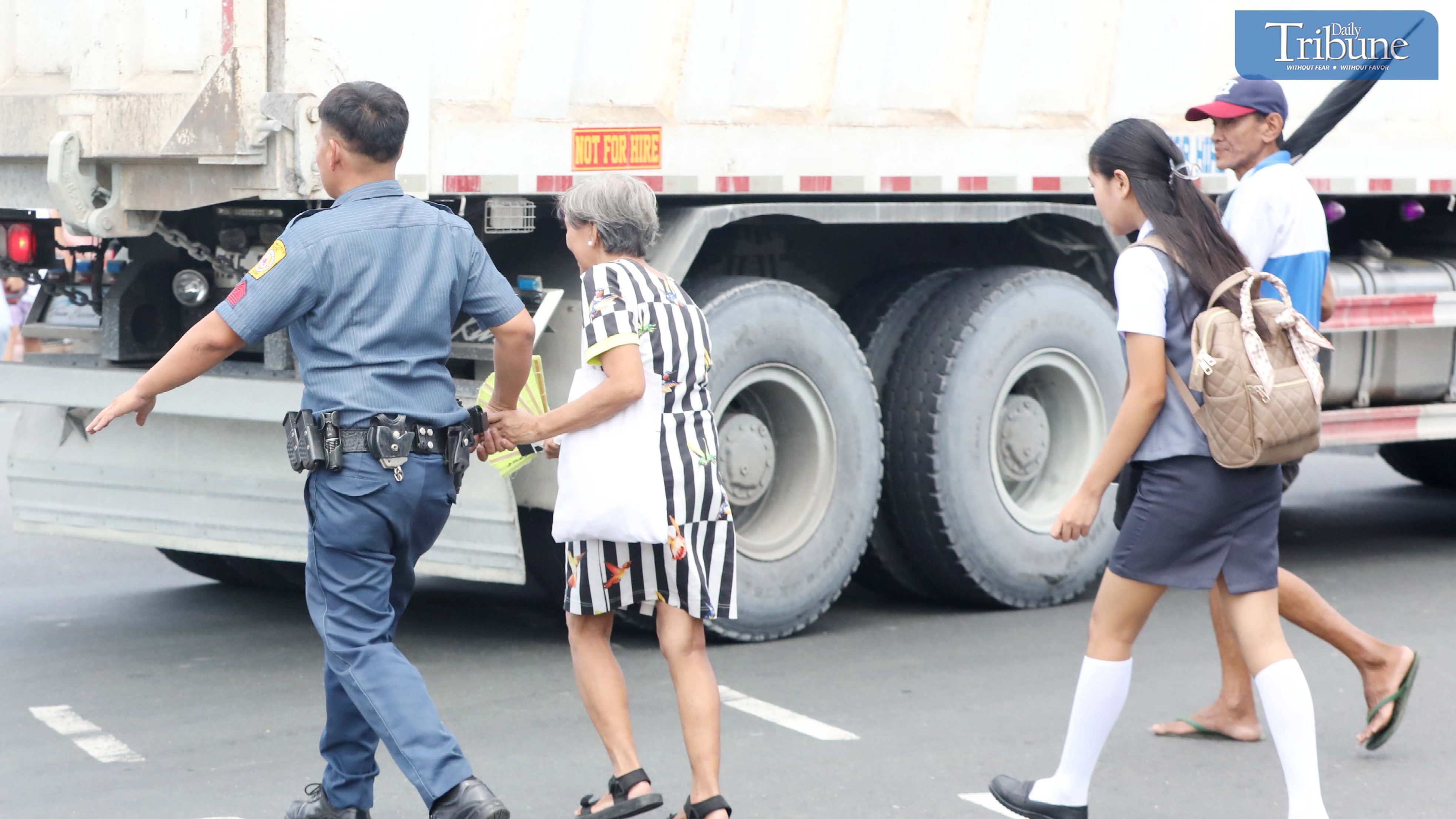 PNP officer assists senior citizen on busy Quezon City road