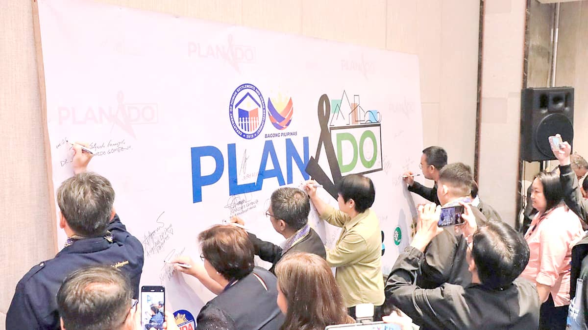 DHSUD and its partner agencies sign the commitment wall to work together in establishing resilient, livable and environmentally-conscious urban communities across the country.