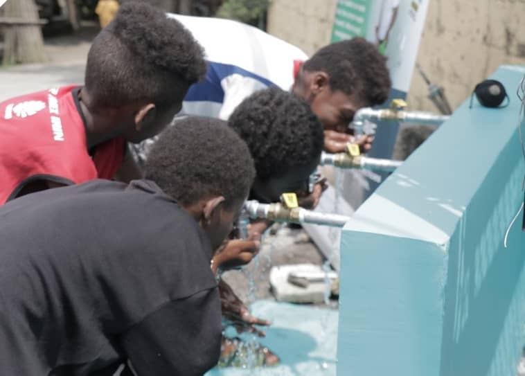 AETA kids drink water from a water station linked to the deep well.