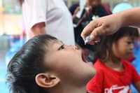 A child receives a dose of oral polio vaccine (OPV) in one of the Sabayang Patak Kontra Polio (SPKP) drives