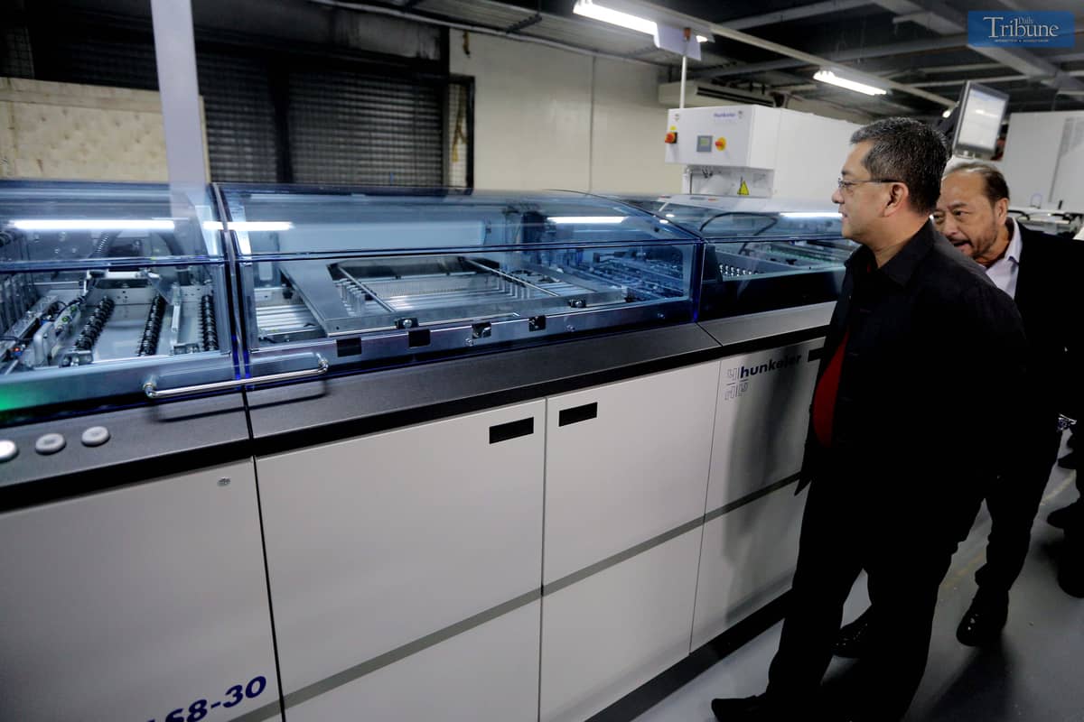Commission on Elections (Comelec) Chairman George Garcia and National Printing Office (NPO) Director III Arjay Lim inspect new printing machines.
