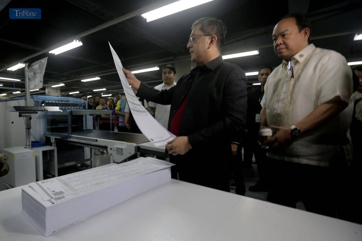 Commission on Elections (Comelec) Chairman George Garcia and National Printing Office (NPO) Director III Arjay Lim inspect new printing machines.