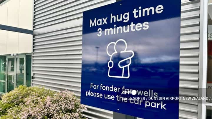 A handout photo taken on 22 October 2024 and received by the Dunedin Airport New Zealand on 24 October, shows a new signage installed as New Zealand airport has imposed a three-minute limit on farewell hugs, sparking a worldwide debate over how long to cling on for a cuddle. | Photo courtesy of Sarah SOPER / DUNEDIN AIRPORT NEW ZEALAND / AFP