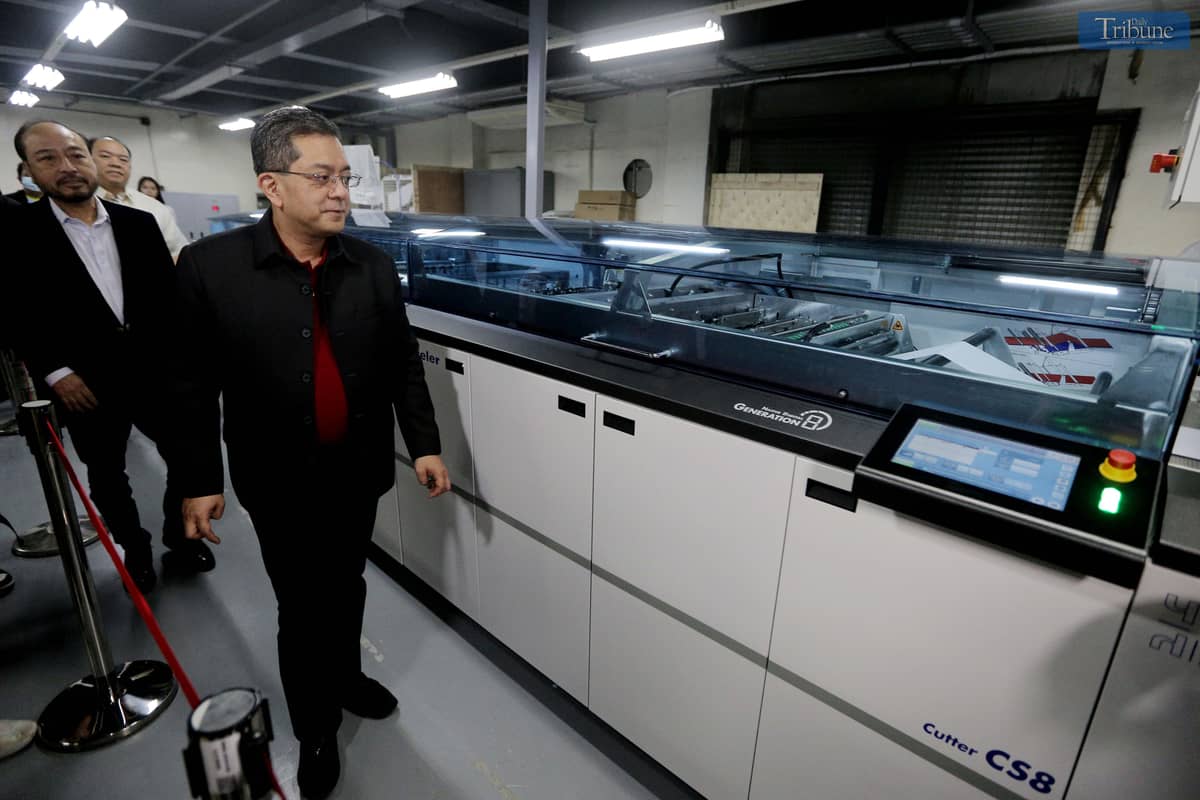 Commission on Elections (Comelec) Chairman George Garcia and National Printing Office (NPO) Director III Arjay Lim inspect new printing machines.