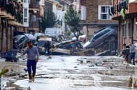Residents are pictured next to cars piled in a street covered in mud following floods in Picanya, near Valencia, eastern Spain, on October 30, 2024. Floods triggered by torrential rains in Spain’s eastern Valencia region has left 51 people dead, rescue services said on October 30.