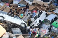 People climb on piled up cars following floods in Sedavi, south of Valencia, eastern Spain, on 30 October, 2024. Floods triggered by torrential rains in Spain's eastern Valencia region has left at least 70 people dead, rescue services said on 30 October.