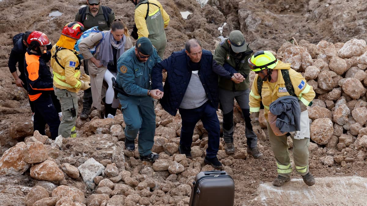 Emergency services staff members help a man following deadly floods in Letur, southwest of Valencia, eastern Spain, on 30 October 2024. Floods triggered by torrential rains in Spain's eastern Valencia region has left at least 70 people dead, rescue services said on 30 October.