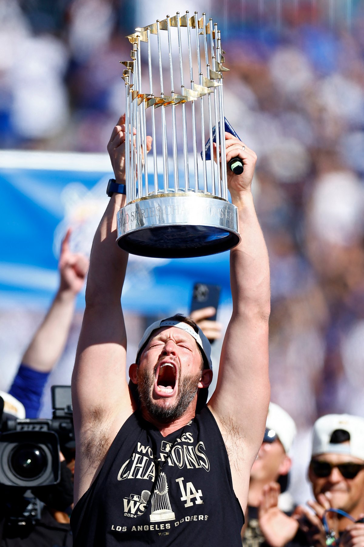 Clayton Kershaw lifts the Commissioner’s Trophy during the 2024 World Series Celebration Show for the Los Angeles Dodgers.