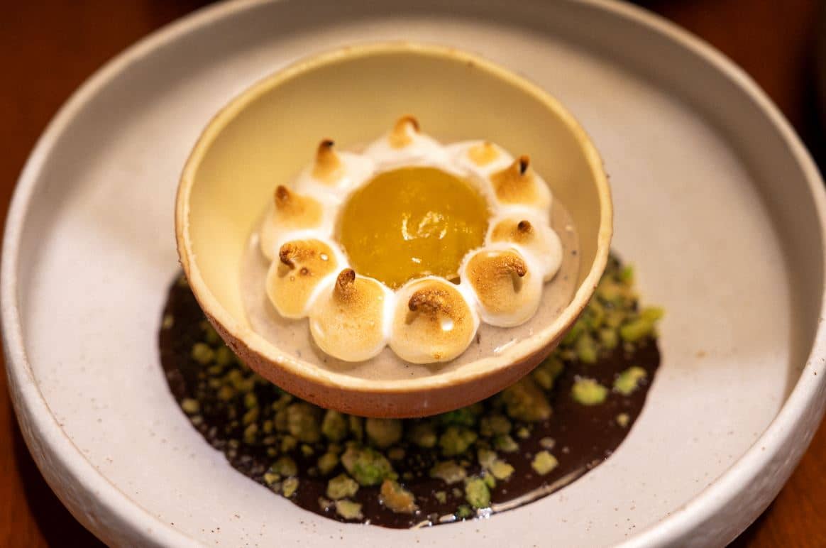 Waterside bombe, espasol crumble, toasted rice ice cream, calamansi meringue, dark chocolate rum sauce flambeed with Quezon lambanog.