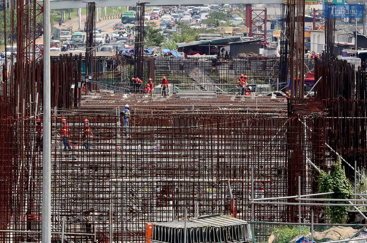Workers continue construction on the Metro Rail Transit (MRT-7) near Techno Hub along Commonwealth Avenue in Quezon City.
