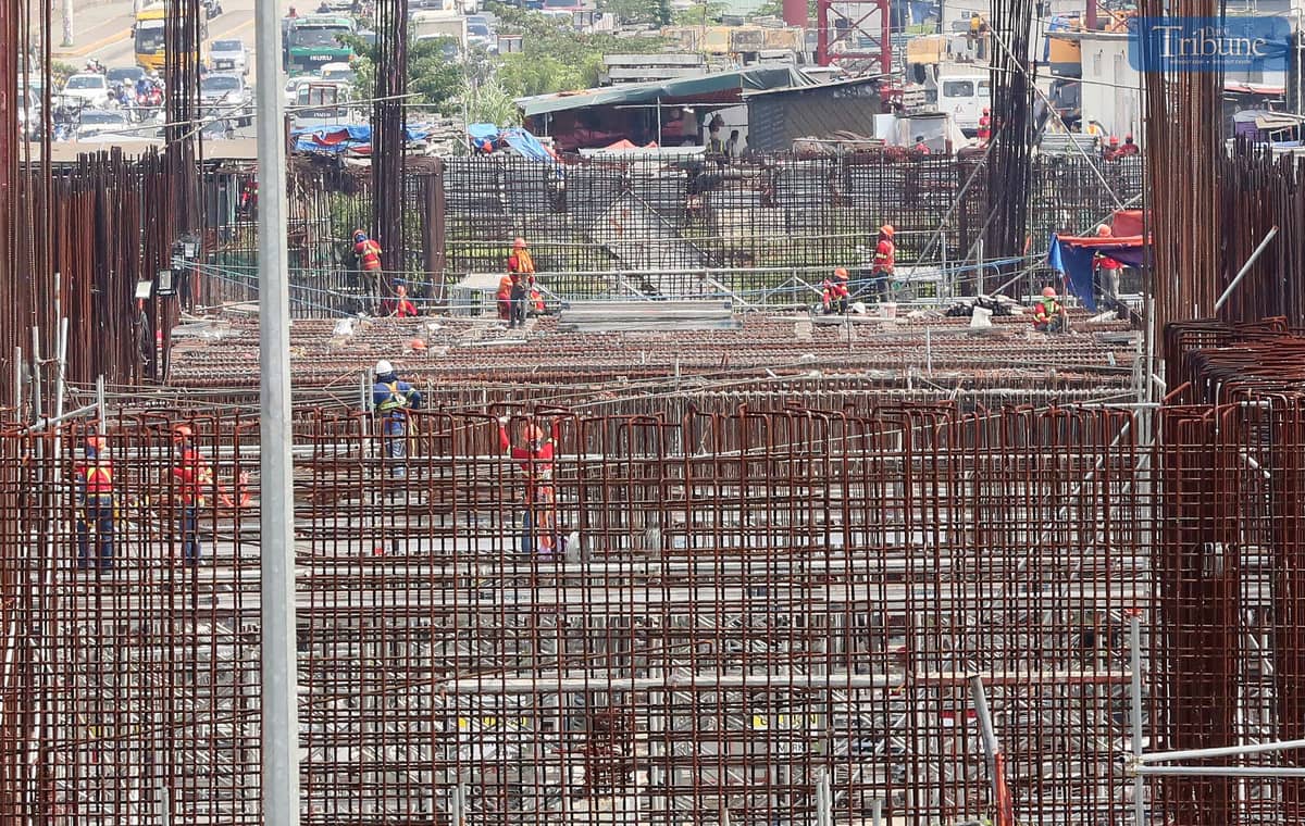 Workers continue construction on the Metro Rail Transit (MRT-7) near Techno Hub along Commonwealth Avenue in Quezon City.