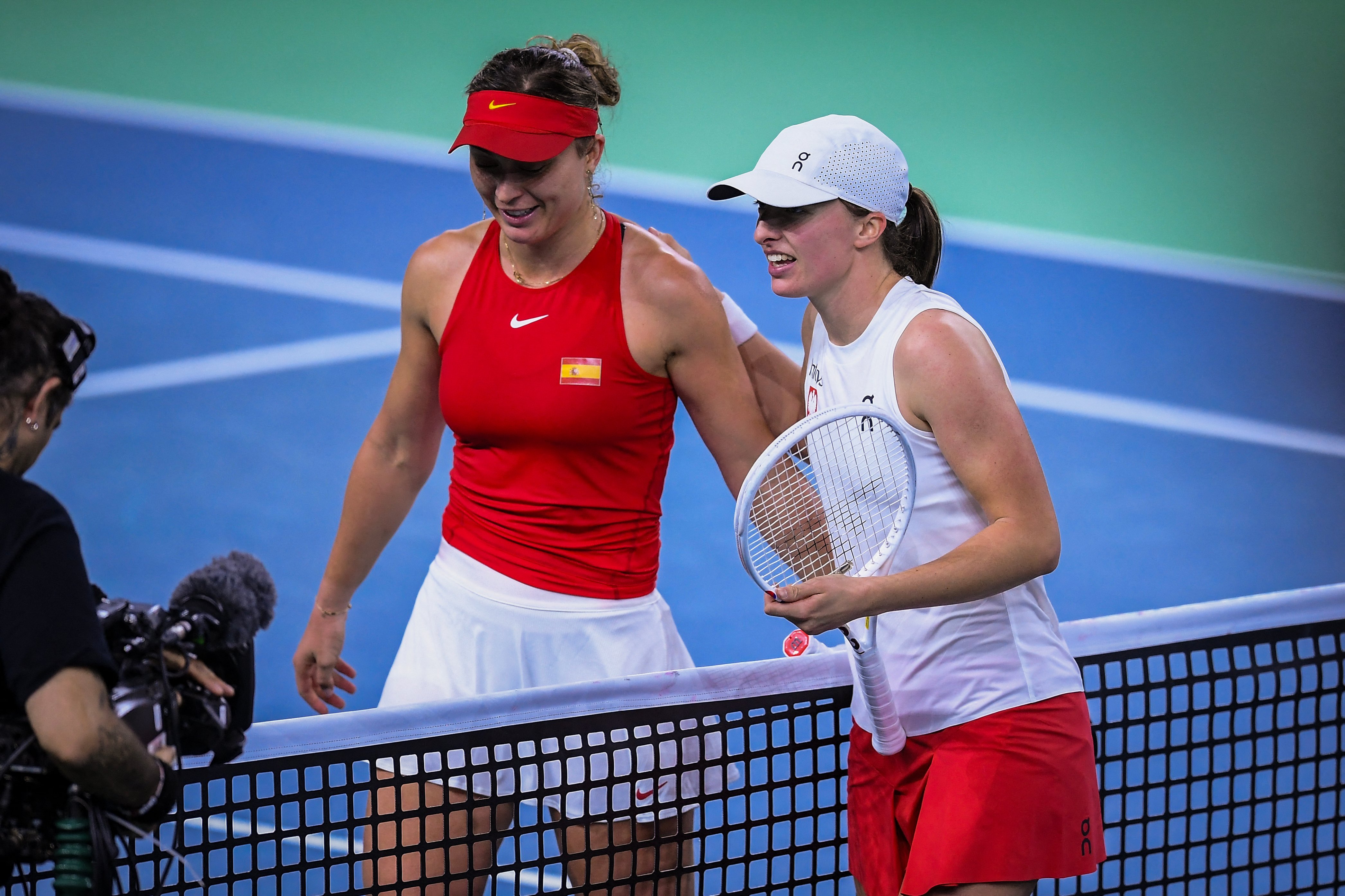 Poland's Iga Swiatek (R) smiles after winning her match against Spain's Paula Badosa during their singles tennis match between Spain and Poland at the Billie Jean King Cup Finals at the Palacio de Deportes Jose Maria Martin Carpena in Malaga, Spain, on November 15, 2024.