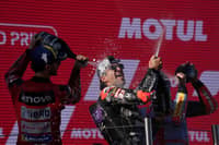 The new world champion Ducati Spanish rider Jorge Martin (C) celebrates on the podium with runner-up Ducati Italian rider Francesco Bagnaia (L) and third placed Ducati Spanish rider Marc Marquez after the MotoGP Solidarity Grand Prix of Barcelona at the Circuit de Catalunya on 17 November, 2024 in Montmelo on the outskirts of Barcelona. Jorge Martin won the MotoGP world title after taking a 24-point lead into the final weekend of the season in Barcelona.