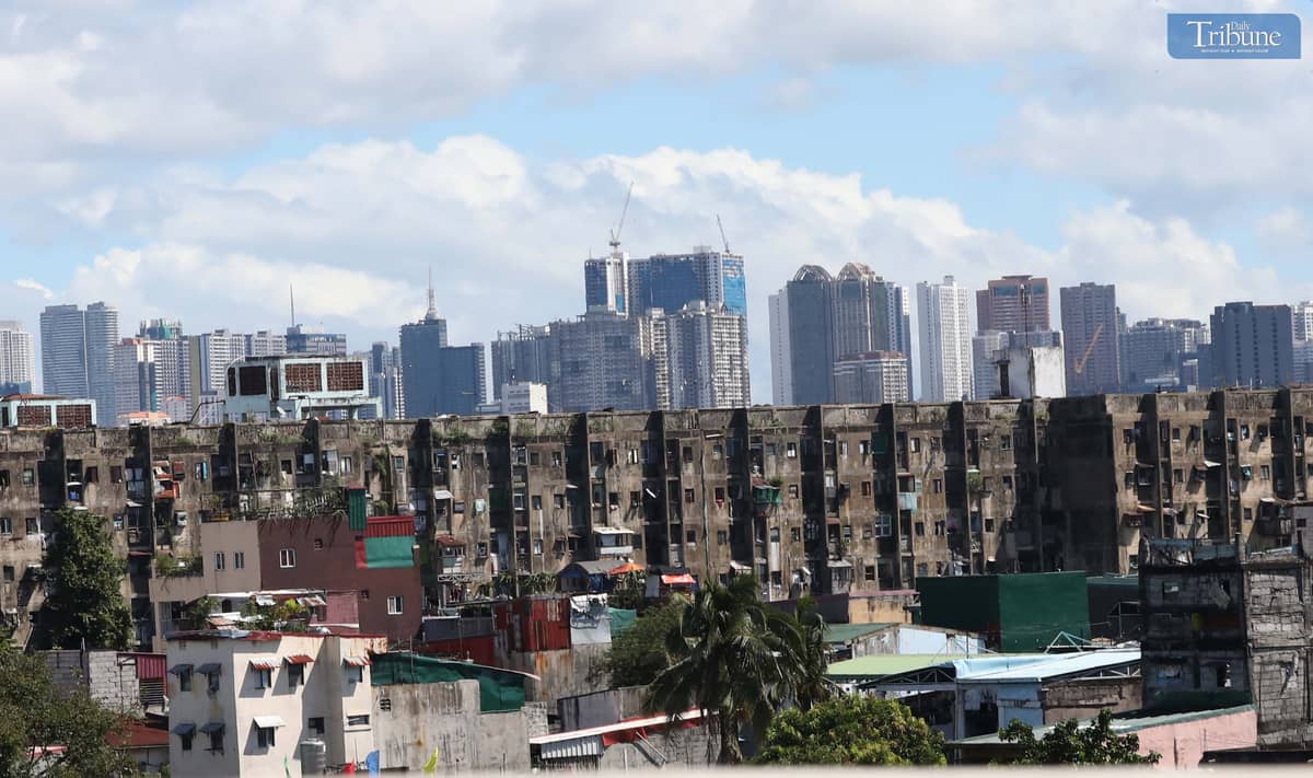 Rows of government housing are dwarfed by the towering skyline of the Makati Business District, as seen from Skyway on 19 November 2024
