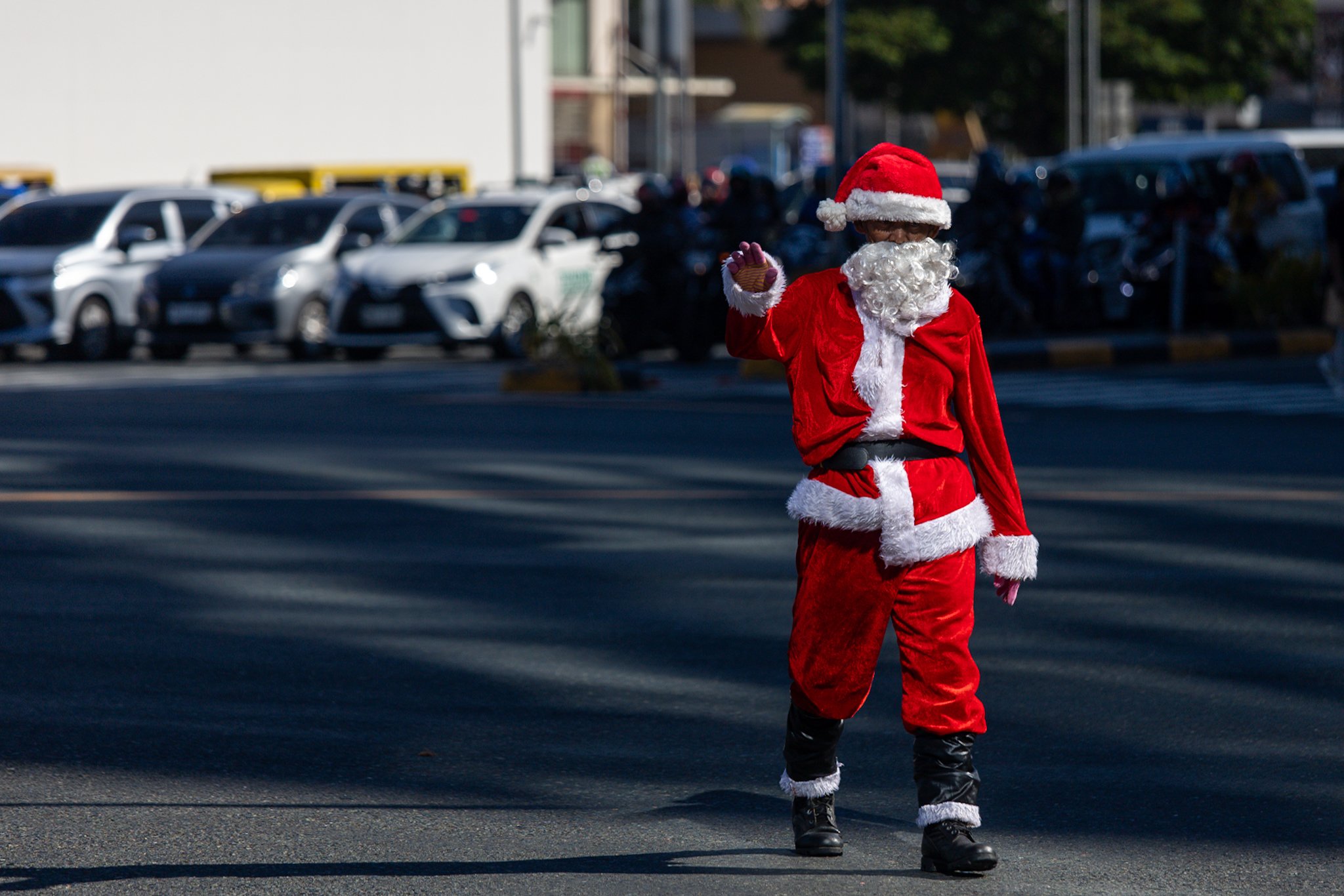 Traffic enforcer directs traffic while wearing Santa Claus costume