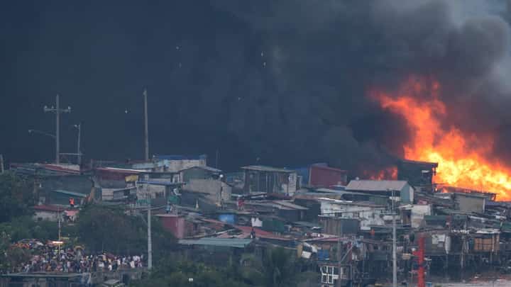 Flames and black smoke rise during a fire in the Isla Puting Bato residential area in Manila on 24 November, 2024.