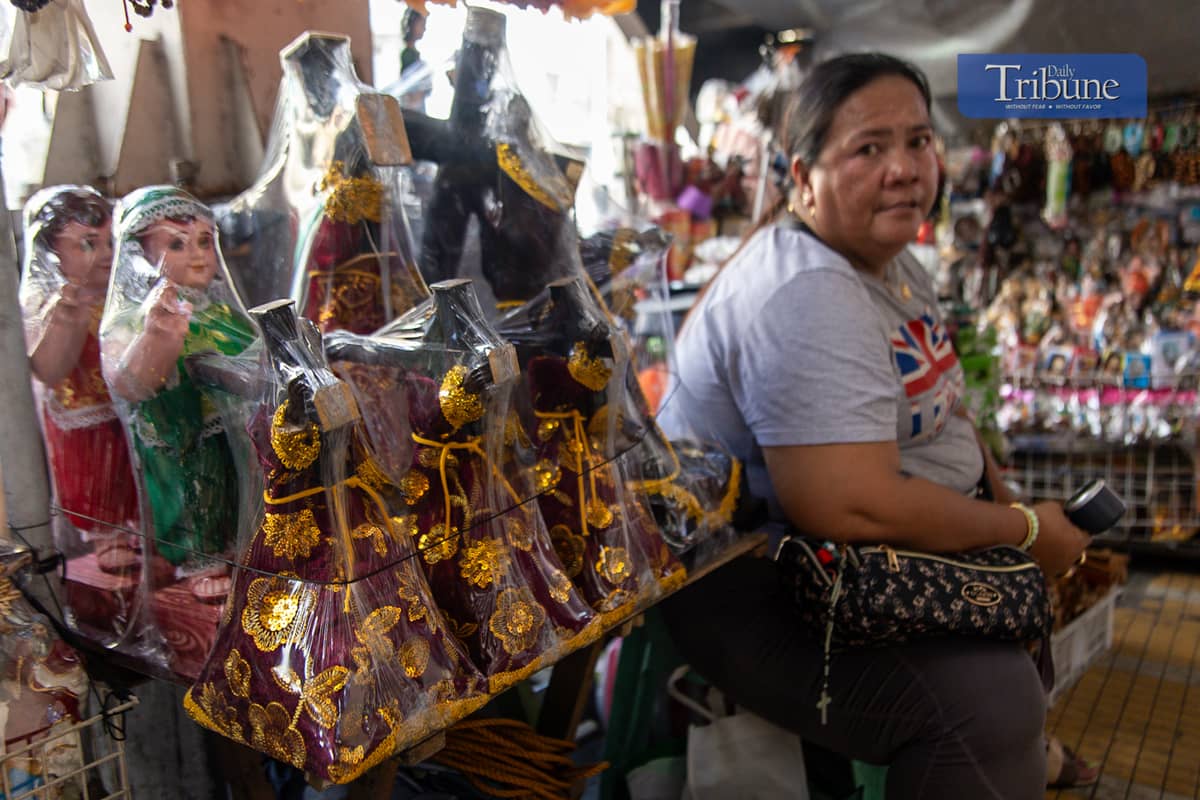 Vendors sell miniature replicas of the Black Nazarene and other devotional items in Quiapo, Manila, on Tuesday, 26 November.