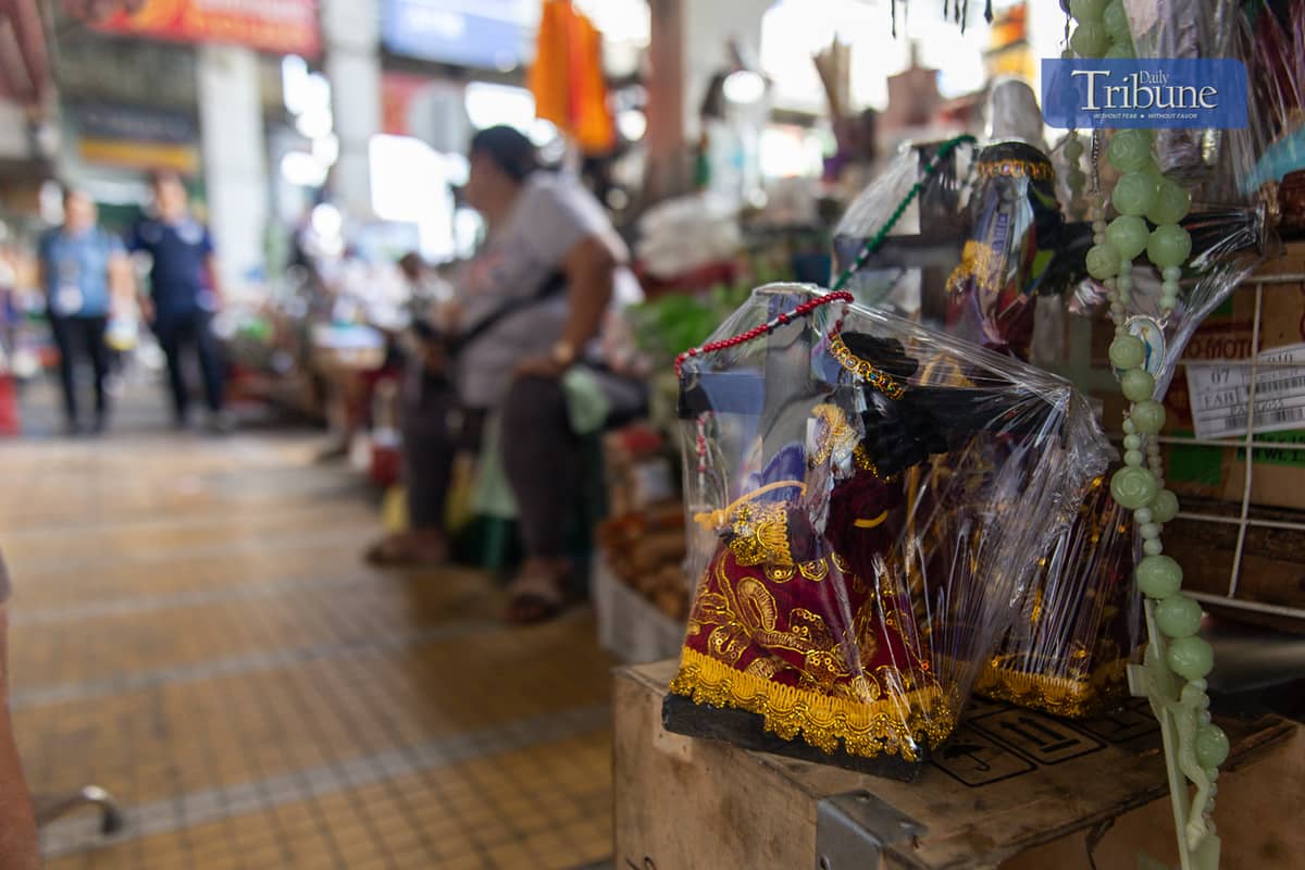 Vendors sell miniature replicas of the Black Nazarene and other devotional items in Quiapo, Manila, on Tuesday, 26 November.