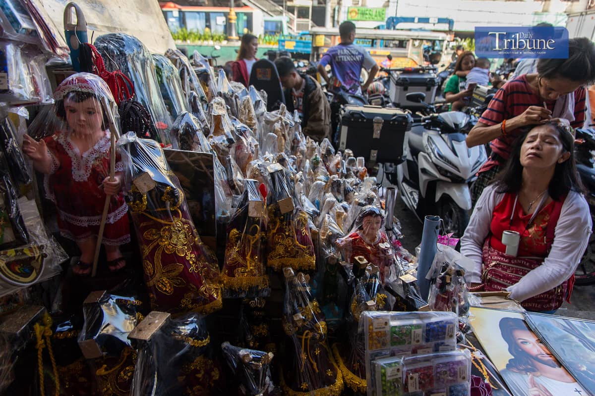 Vendors sell miniature replicas of the Black Nazarene and other devotional items in Quiapo, Manila, on Tuesday, 26 November.