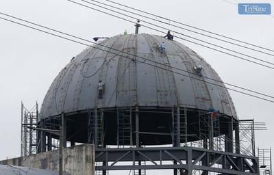 Workers install columbarium dome