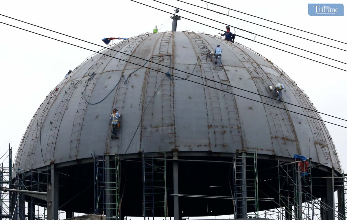 Workers balance on the dome of a columbarium under construction along Commonwealth Avenue in Quezon City on Monday, 2 December.