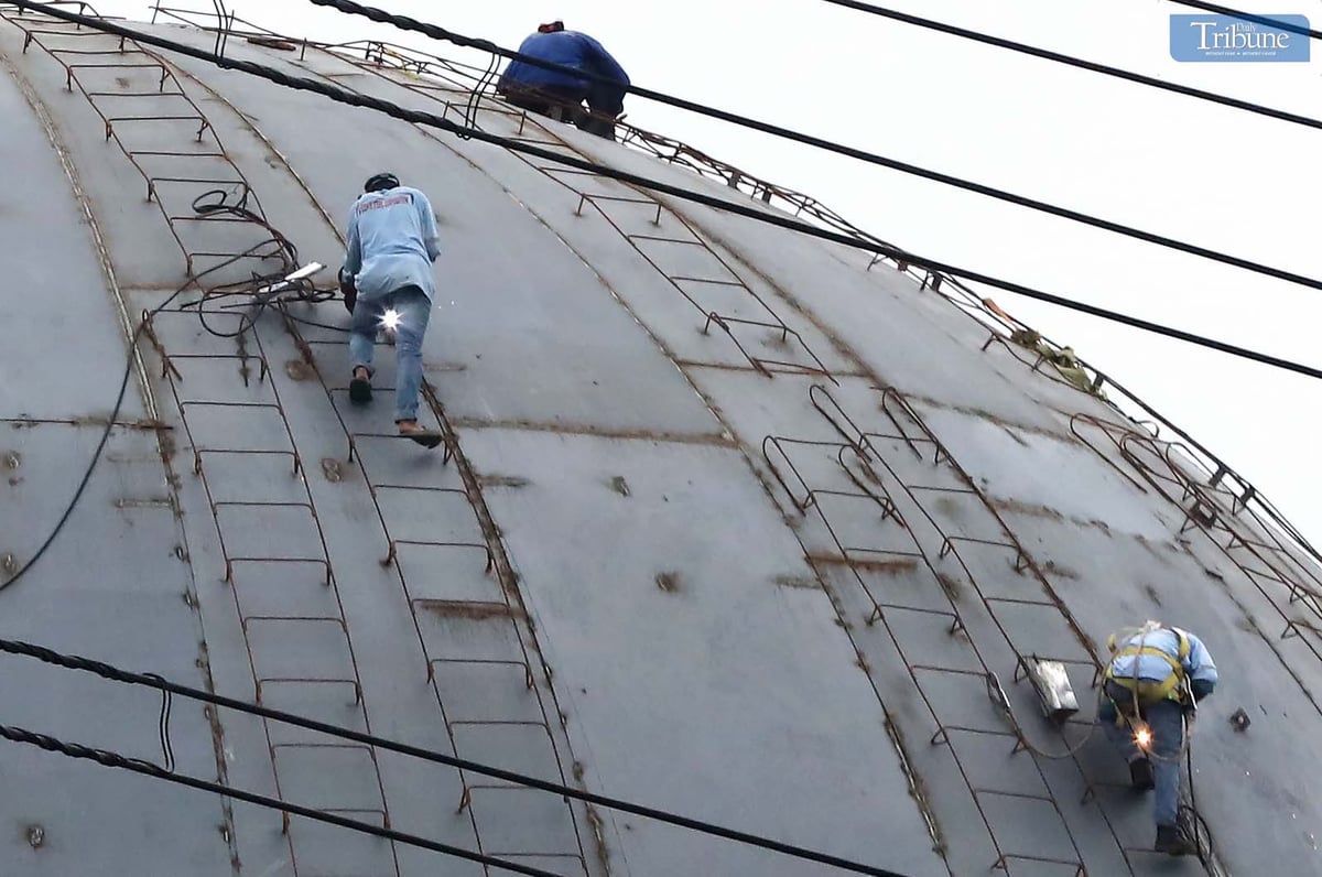 Workers balance on the dome of a columbarium under construction along Commonwealth Avenue in Quezon City on Monday, 2 December.