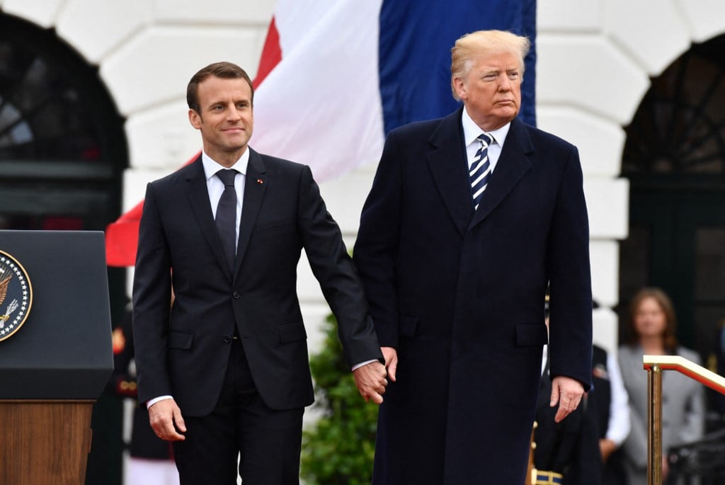 (FILES) French President Emmanuel Macron and US President Donald Trump join hands during a state welcome at the White House in Washington, DC, on April 24, 2018. Donald Trump will attend the weekend reopening of the restored Notre Dame cathedral in Paris, in his first trip abroad as US president-elect, he announced on social media on December 2, 2024.