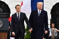 (FILES) French President Emmanuel Macron and US President Donald Trump join hands during a state welcome at the White House in Washington, DC, on April 24, 2018. Donald Trump will attend the weekend reopening of the restored Notre Dame cathedral in Paris, in his first trip abroad as US president-elect, he announced on social media on December 2, 2024.