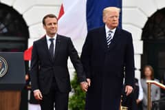 (FILES) French President Emmanuel Macron and US President Donald Trump join hands during a state welcome at the White House in Washington, DC, on April 24, 2018. Donald Trump will attend the weekend reopening of the restored Notre Dame cathedral in Paris, in his first trip abroad as US president-elect, he announced on social media on December 2, 2024.