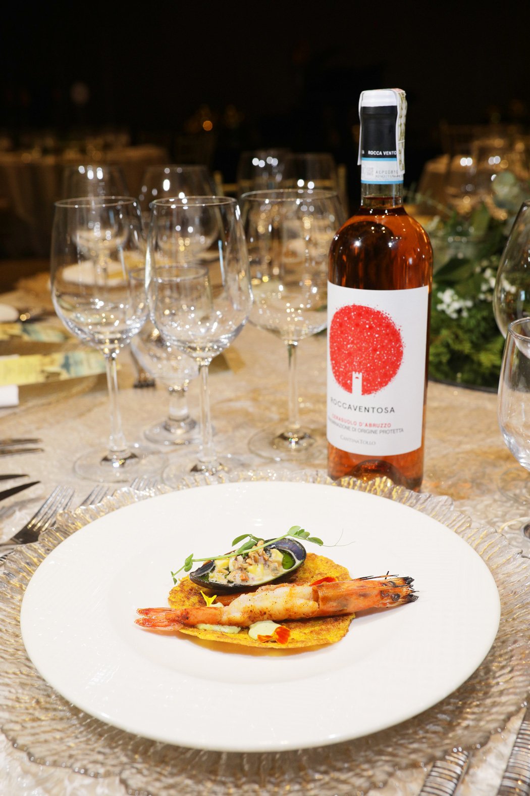First entrée — Paella Marisco Soccarat featuring burnt paella rice, grilled prawns, and mussel ceviche, paired with Rocca Ventosa Trebbiano d’Abruzzo DOP, Italy.