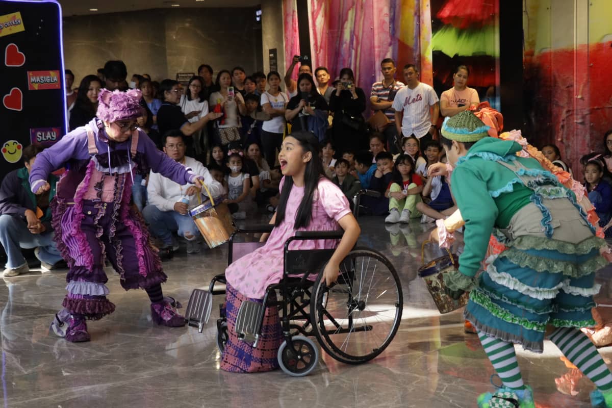 A lady in a wheelchair joins in the program.