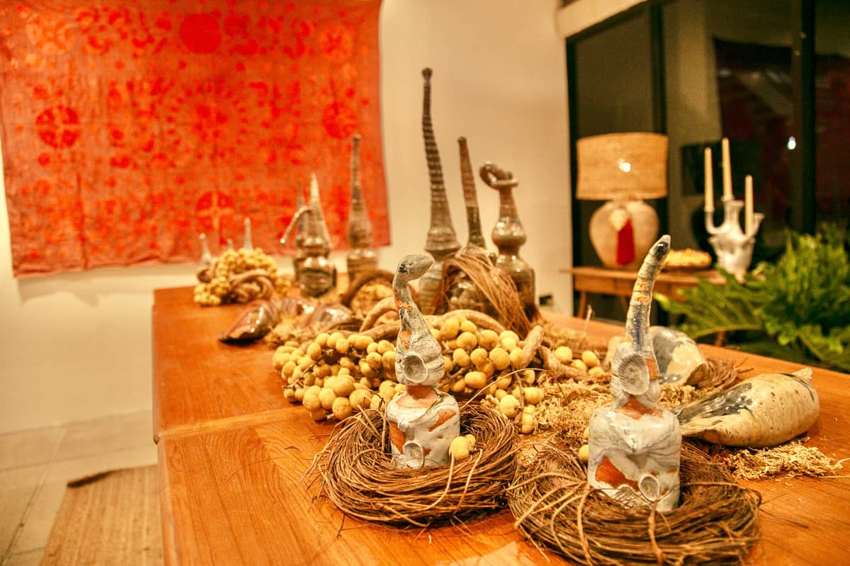 Solon Perfecto’s sculptures have tall, pointy hats, volatile glaze movements on the body, and slip brushstrokes that portray the nature and rural surroundings of his studio.