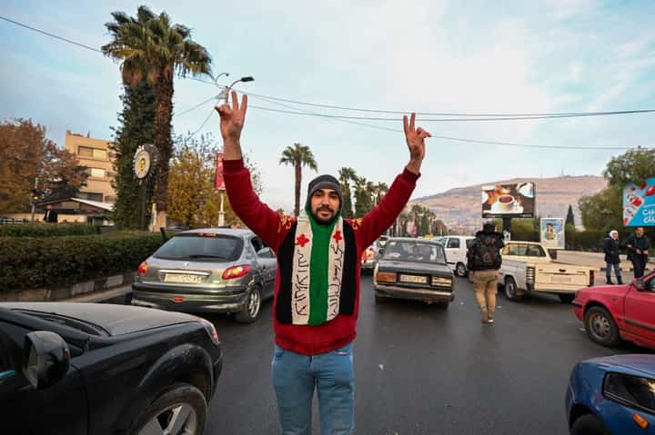 A man cheers on a street in Damascus on December 8, 2024. Islamist-led rebels declared that they have taken Damascus in a lightning offensive on on December 8, sending President Bashar al-Assad fleeing and ending five decades of Baath rule in Syria.