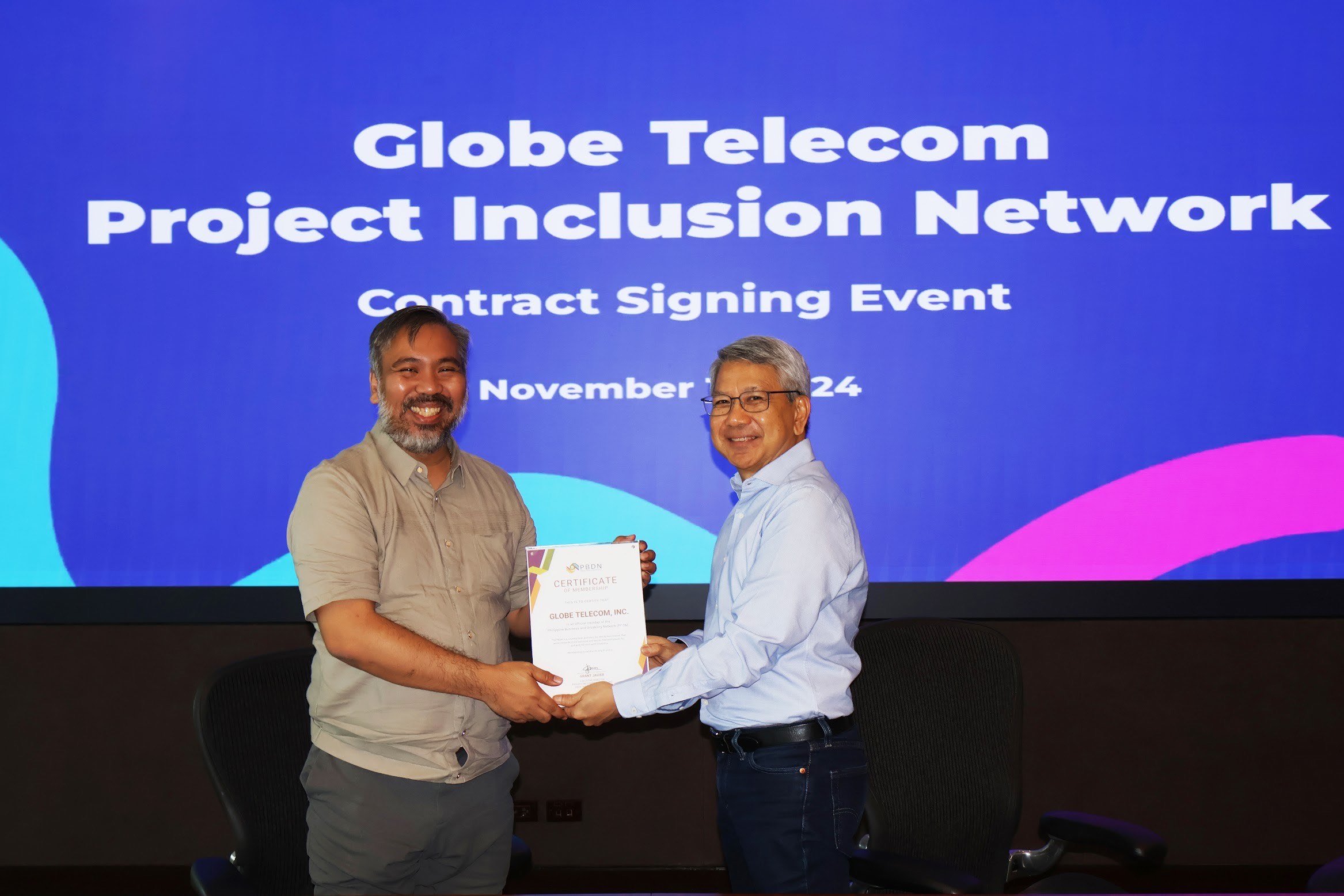 Grant Javier (left), CEO of PIN and lead convener of PBDN, presents a certificate of membership to Renato Jiao, chief human resource officer of Globe.
