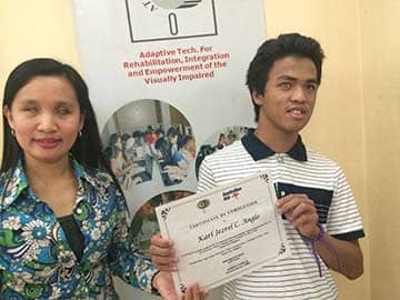 Karl Jezrel Anglo (right) receives a training certificate from Des B. Borgonia of ATRlEV which trains PWDs to become IT workers.