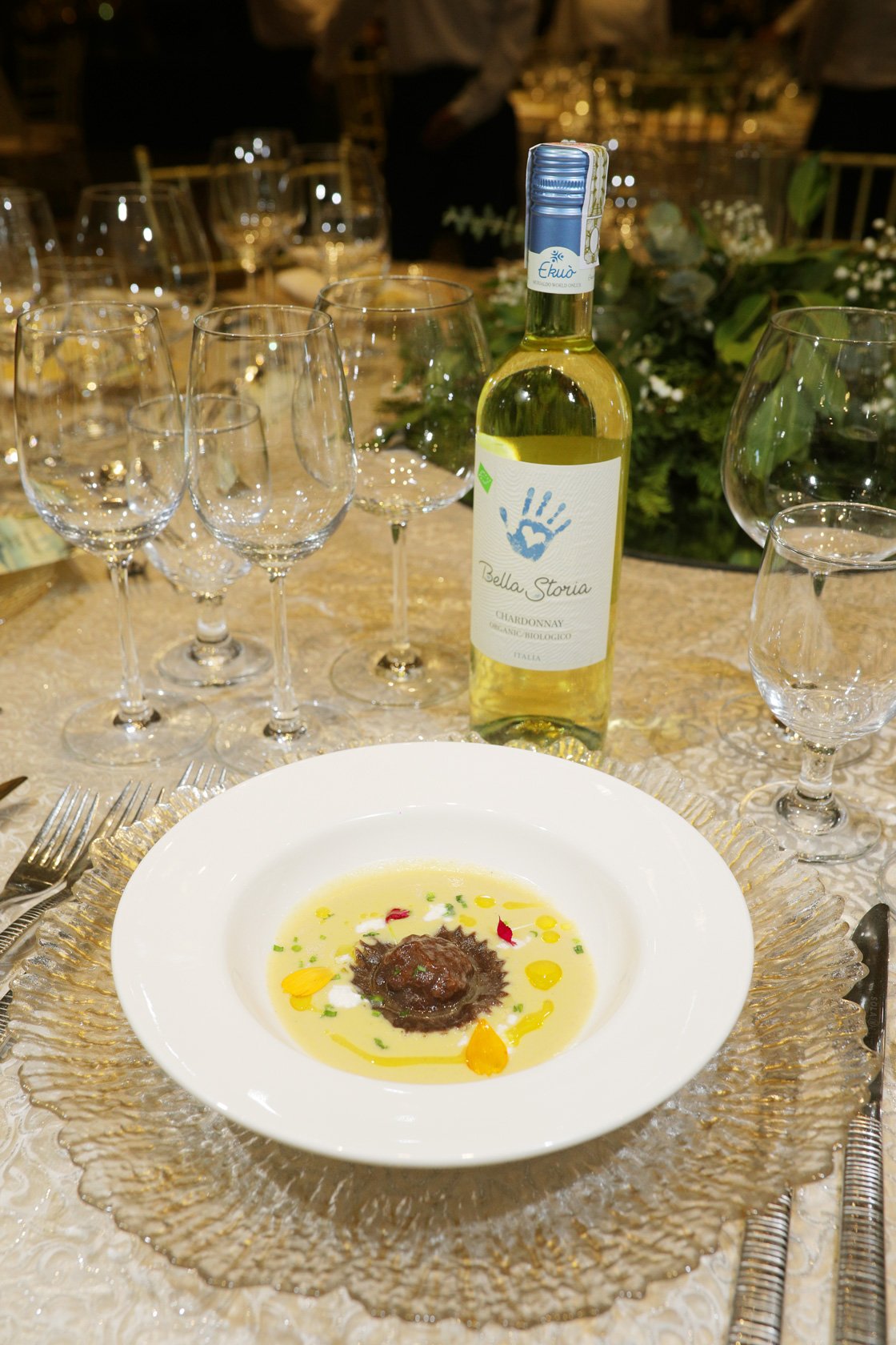 Amuse Bouche — homemade Chocolate Ravioli filled with Alfonso tablea, braised beef, and ricotta, topped with parmesan and molé blanco, paired with Bella Storia Chardonnay, Italy.