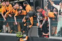 Lando Norris celebrates with the McLaren crew after winning the Abu Dhabi Grand Prix to seal the constructors' title